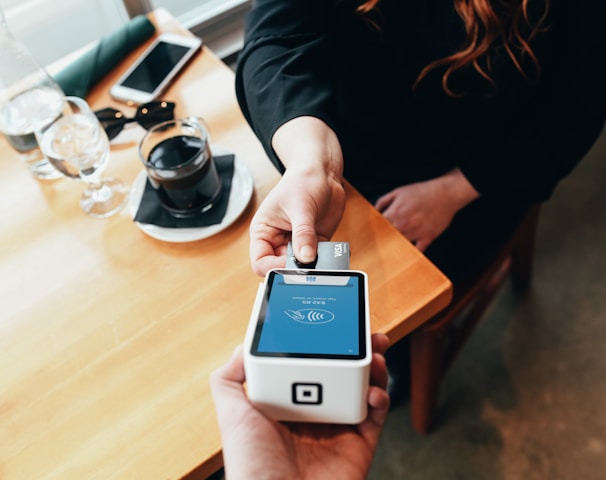 person holding credit card swipe machine