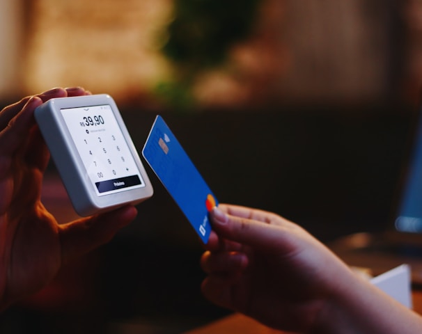 a person holding a credit card and a cell phone