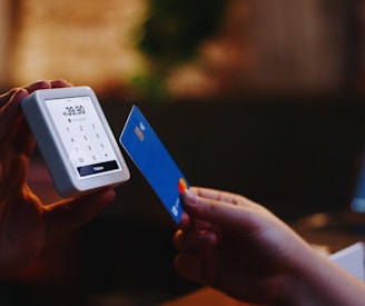 a person holding a credit card and a cell phone